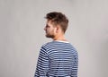 Hipster man in striped t-shirt, gray background, studio shot