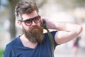 Hipster man with stylish beard and mustache walking in city. Closeup portrait of handsome young man in trendy eyewear Royalty Free Stock Photo