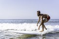 Hipster man surfing with a longboard on the waves - Fit guy training with a surfboard on a slightly rough sea - Water sport, Royalty Free Stock Photo