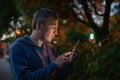 Hipster man talking on a mobile phone at night in the city against the background of bokeh lights. Royalty Free Stock Photo