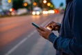 Hipster man talking on a mobile phone at night in the city against the background of bokeh lights Royalty Free Stock Photo