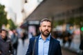 Hipster manager in blue shirt walking in the street