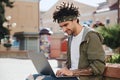 Hipster millennial guy working on freelance using modern laptop computer enjoying spending time outdoors. Freelancer searching