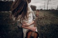 Hipster musician couple hugging in field, handsome man embracing