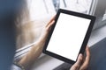 Hipster person hands holding digital tablet with empty blank screen, against a background of window horizontal, freelancer girl Royalty Free Stock Photo