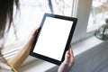 Hipster person hands holding digital tablet with empty blank screen, against a background of window horizontal, freelancer girl Royalty Free Stock Photo