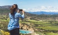 Hipster photograph on smart phone gadget mobile, mock up of blank screen. Girl traveler hold in hand mobile on background mountain