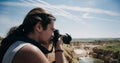 Hipster photographer traveler taking a shot of beautiful landscape