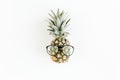 Hipster pineapple in glasses on white background. Flat lay, top view