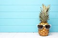 Hipster pineapple with sunglasses against blue wood Royalty Free Stock Photo