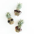 Hipster pineapples in glasses on white background. Flat lay, top view