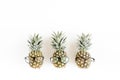 Hipster pineapples in glasses on white background. Flat lay, top view