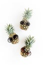 Hipster pineapples in glasses on white background. Flat lay, top view