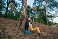 Hipster portrait brutal bearded and moustached woodcutter Gypsy man in the forest with ax. Travel style