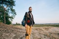 Hipster portrait brutal bearded and moustached woodcutter Gypsy man in the forest with ax. Travel style