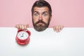 Hipster with red clock on pink background. Royalty Free Stock Photo