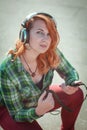 Hipster redhead girl with headphones listening music Royalty Free Stock Photo