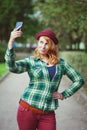 Hipster redhead woman in hat taking picture of herself Royalty Free Stock Photo