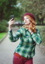 Hipster redhead woman in hat taking picture of herself Royalty Free Stock Photo