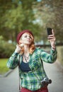 Hipster redhead woman in hat taking picture of herself Royalty Free Stock Photo