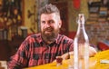 Hipster relaxing at bar. Bar relaxing place to have drink and relax. Man with beard spend leisure drinking strong