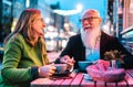 Hipster retired senior couple in love enjoying cappuccino at outdoor cafeteria - Joyful elderly lifestyle concept