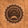 Hipster's badge on brown crumbled textured paper background Royalty Free Stock Photo