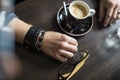 Hipster`s hands with a cup of coffee in the cafe at the table, close-up Royalty Free Stock Photo