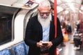 Hipster senior man chat messaging on mobile phone in subway train - Focus on face Royalty Free Stock Photo