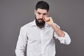 Hipster with serious face. Feeling and emotions. Guy or bearded man on grey background. Barber fashion and beauty. Man Royalty Free Stock Photo