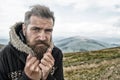 Hipster with serious face at mountains. Royalty Free Stock Photo