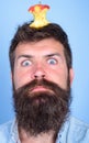 Hipster shocked face with apple stump target on head blue background, close up. Weight loss goal. Man handsome hipster