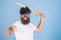 Hipster on shouting face enjoy play game in virtual reality. VR gamer concept. Man with beard in VR glasses, light blue