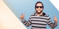 Composite image of hipster showing rock and roll hand sign Royalty Free Stock Photo