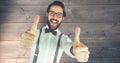 Hipster showing thumbs up against wall