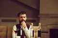 Hipster sitting at table with three bottles and glass Royalty Free Stock Photo