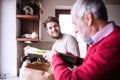 Hipster son with his senior father in the kitchen. Royalty Free Stock Photo