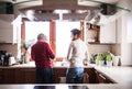 Hipster son with his senior father in the kitchen. Royalty Free Stock Photo