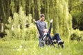 Hipster son walking with disabled father in wheelchair at park. Royalty Free Stock Photo