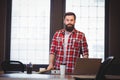 Hipster standing by desk in creative office