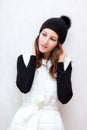 Hipster Style Brunette Girl Swag wearing Black fashion beanie knitted hat with bumbon pumpon. Season Fall Winter