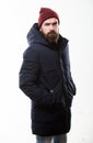 Hipster style menswear. Hipster outfit. Man bearded hipster posing confidently in warm black jacket or parka. Stylish