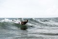 Hipster surfer slipping on the waves lying on his board with a big wave in sea - Bearded man training with surfboard to sea -