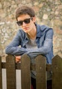 Hipster teenager with sunglasses over a fence Royalty Free Stock Photo