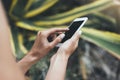 Hipster text message on smart phone or technology, mock up of blank screen. Young girl using cellphone on yellow flower background Royalty Free Stock Photo