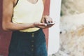 Hipster text message on smart phone or technology, mock up of blank screen. Young girl using cellphone on yellow flower background Royalty Free Stock Photo