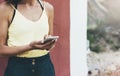 Hipster text message on smart phone or technology, mock up of blank screen. Young girl using cellphone on yellow flower background Royalty Free Stock Photo