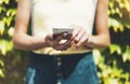 Hipster text message on smart phone or technology, mock up of blank screen. Young girl using cellphone on yellow flower background Royalty Free Stock Photo