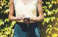 Hipster text message on smart phone or technology, mock up of blank screen. Young girl using cellphone on yellow flower background Royalty Free Stock Photo