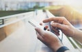 Hipster texting message on smartphone or technology, mock up of blank screen. Tourist using cellphone on bridge background close